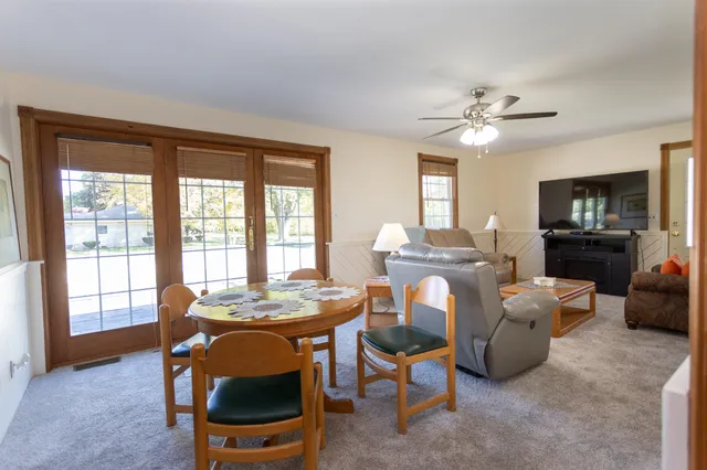 a living room with furniture a fireplace a flat screen tv and windows