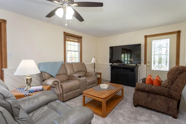 a living room with furniture a chandelier and a window