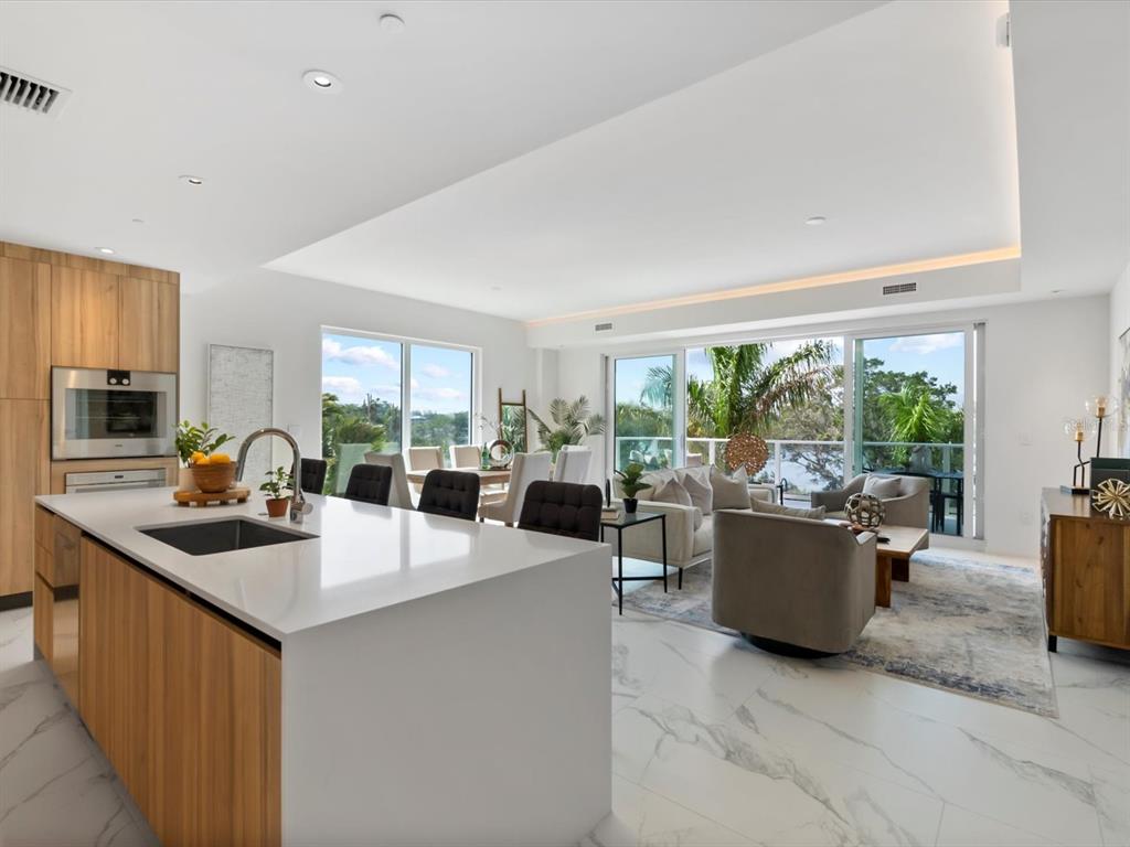 1020 Sunset Point Road, Unit 213 Clearwater, FL 33755 - Photo 13 of 42 a kitchen with sink refrigerator and couches