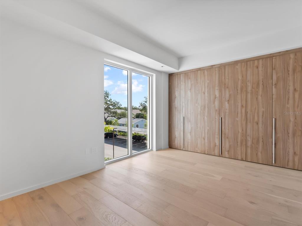 1020 Sunset Point Road, Unit 213 Clearwater, FL 33755 - Photo 38 of 42 a view of an empty room with wooden floor and a window
