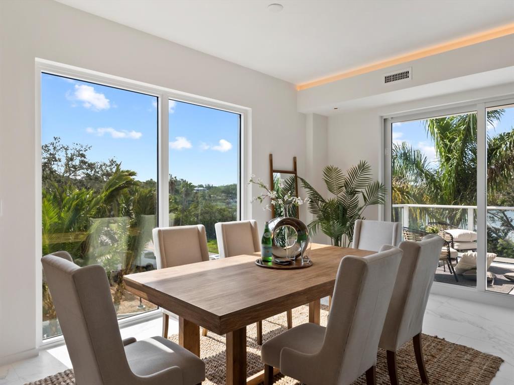 1020 Sunset Point Road, Unit 213 Clearwater, FL 33755 - Photo 5 of 42 a view of a dining room with furniture large windows and wooden floor