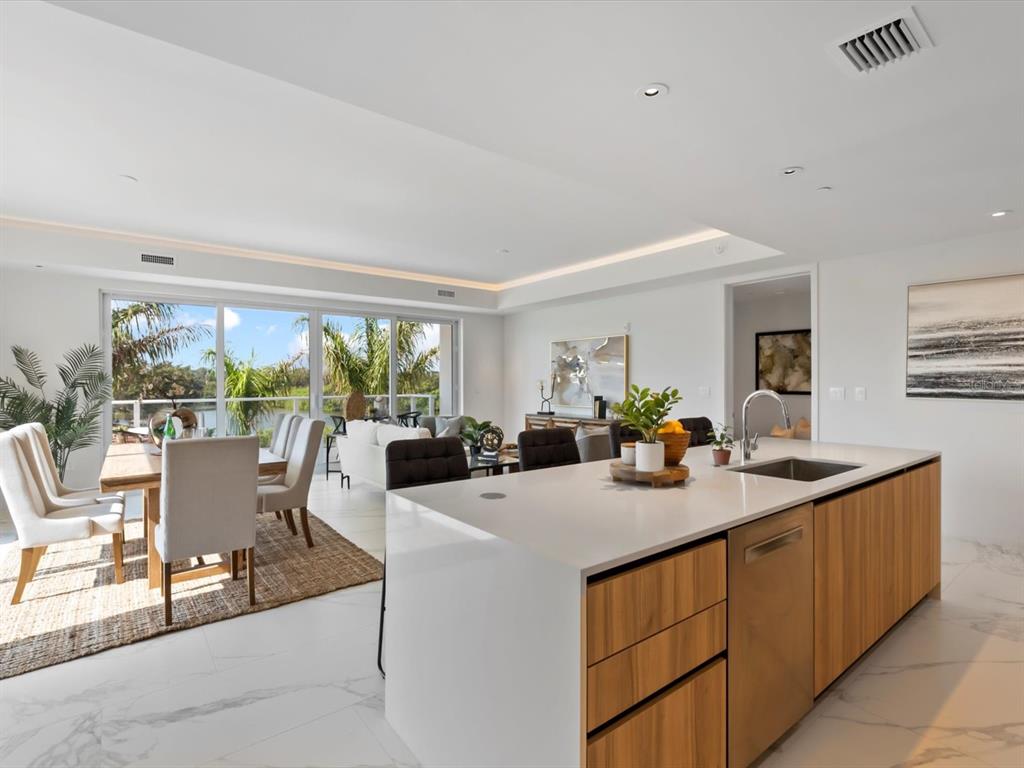 1020 Sunset Point Road, Unit 213 Clearwater, FL 33755 - Photo 10 of 42 a view of a kitchen counter top space with furniture and garden view