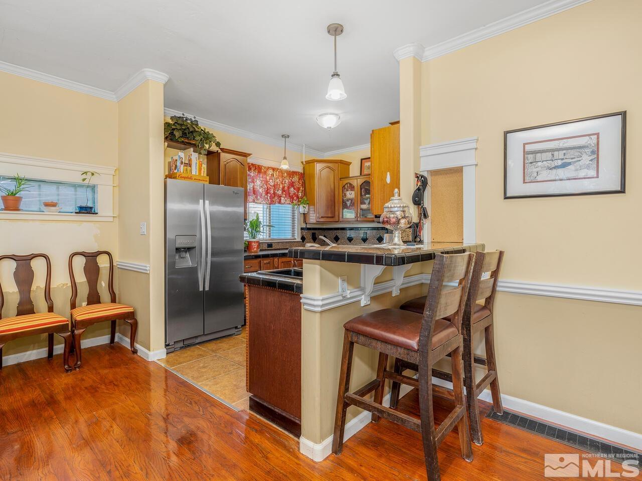 775 Aitken Street Reno, NV 89502 - Photo 6 of 21 a kitchen with stainless steel appliances granite countertop a dining table chairs refrigerator and sink