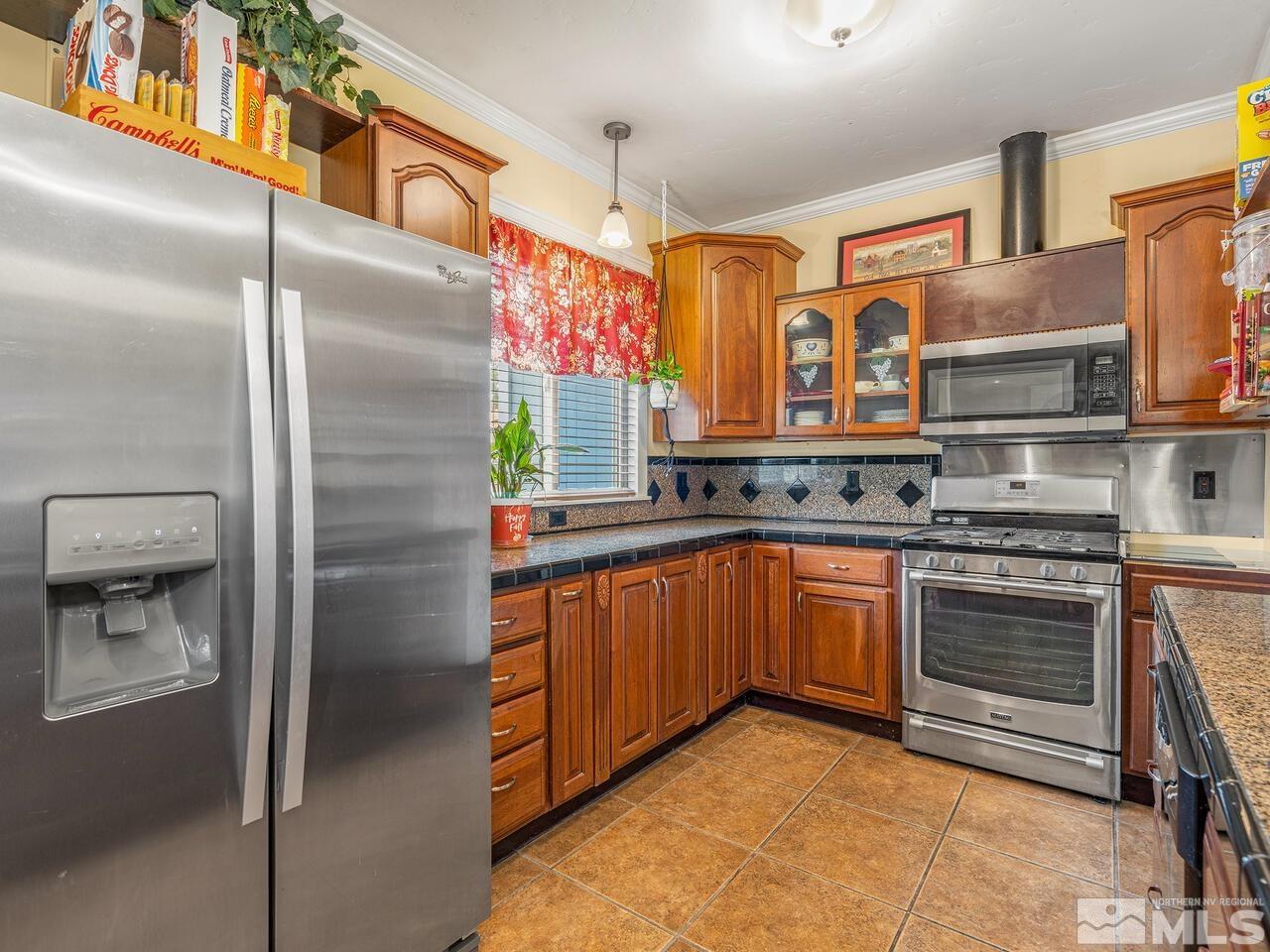 775 Aitken Street Reno, NV 89502 - Photo 8 of 21 a kitchen with stainless steel appliances granite countertop a refrigerator and a stove top oven