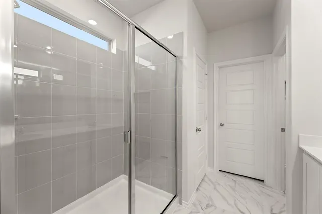 a bathroom with a shower and a glass door