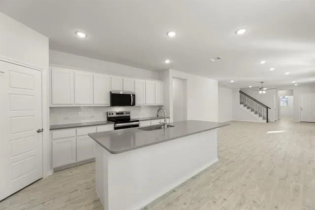 a kitchen with stainless steel appliances granite countertop a sink and a stove