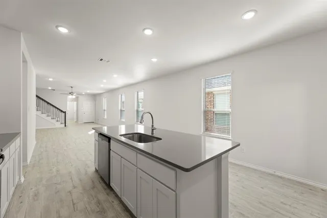 a kitchen with stainless steel appliances granite countertop a sink a stove and a refrigerator