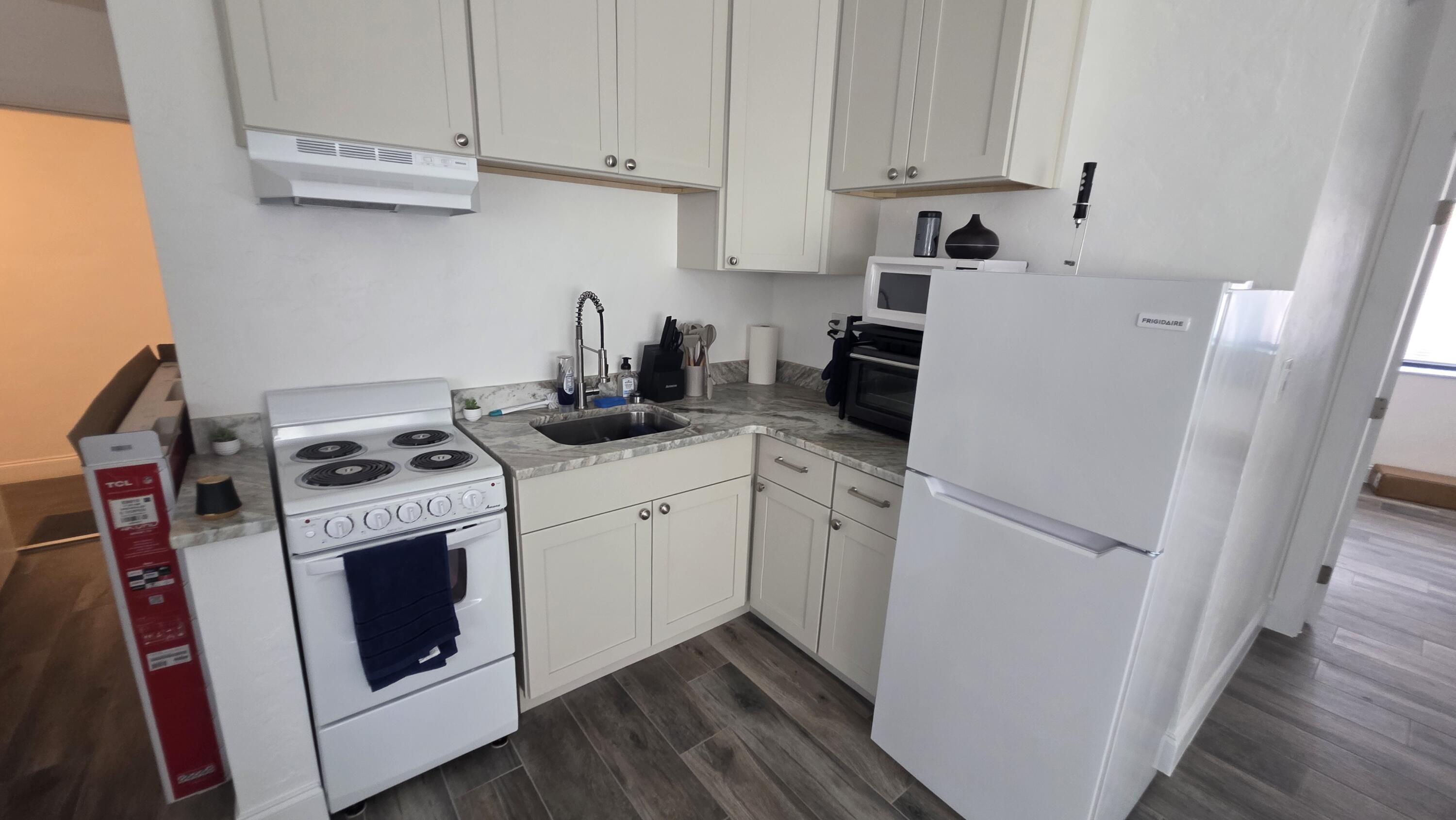 117 North 5th Street Fort Pierce, FL 34950 - Photo 22 of 30 a kitchen with stainless steel appliances white cabinets sink and a stove