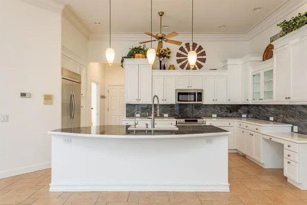 a large kitchen with a refrigerator a stove a microwave and living room view