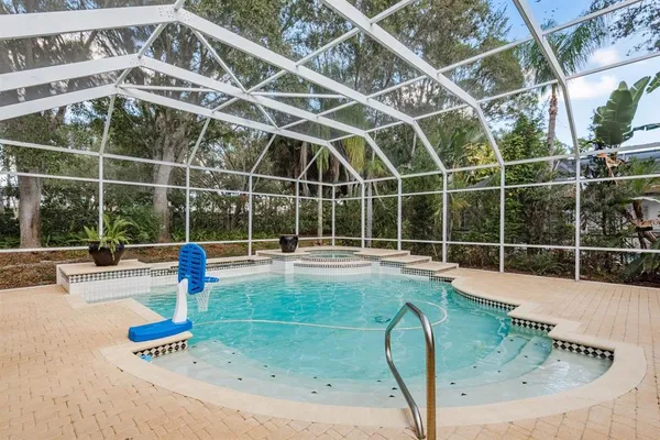 a view of a swimming pool with a yard and plants