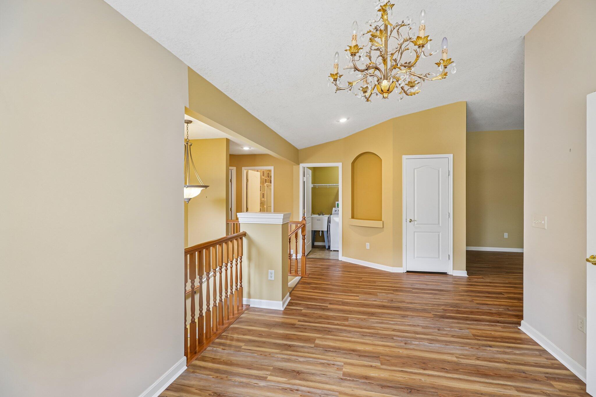 876 Flint Ridge Newport, KY 41076 - Photo 14 of 43 Vaulted ceiling with an ornate chandelier, wood-finish flooring, architectural niche, and a dedicated laundry area