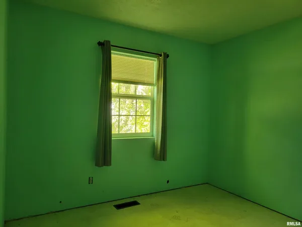 a view of an empty room with window and closet