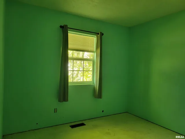 a view of an empty room with window and closet