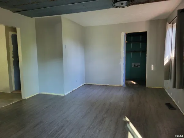 an empty room with wooden floor and closet