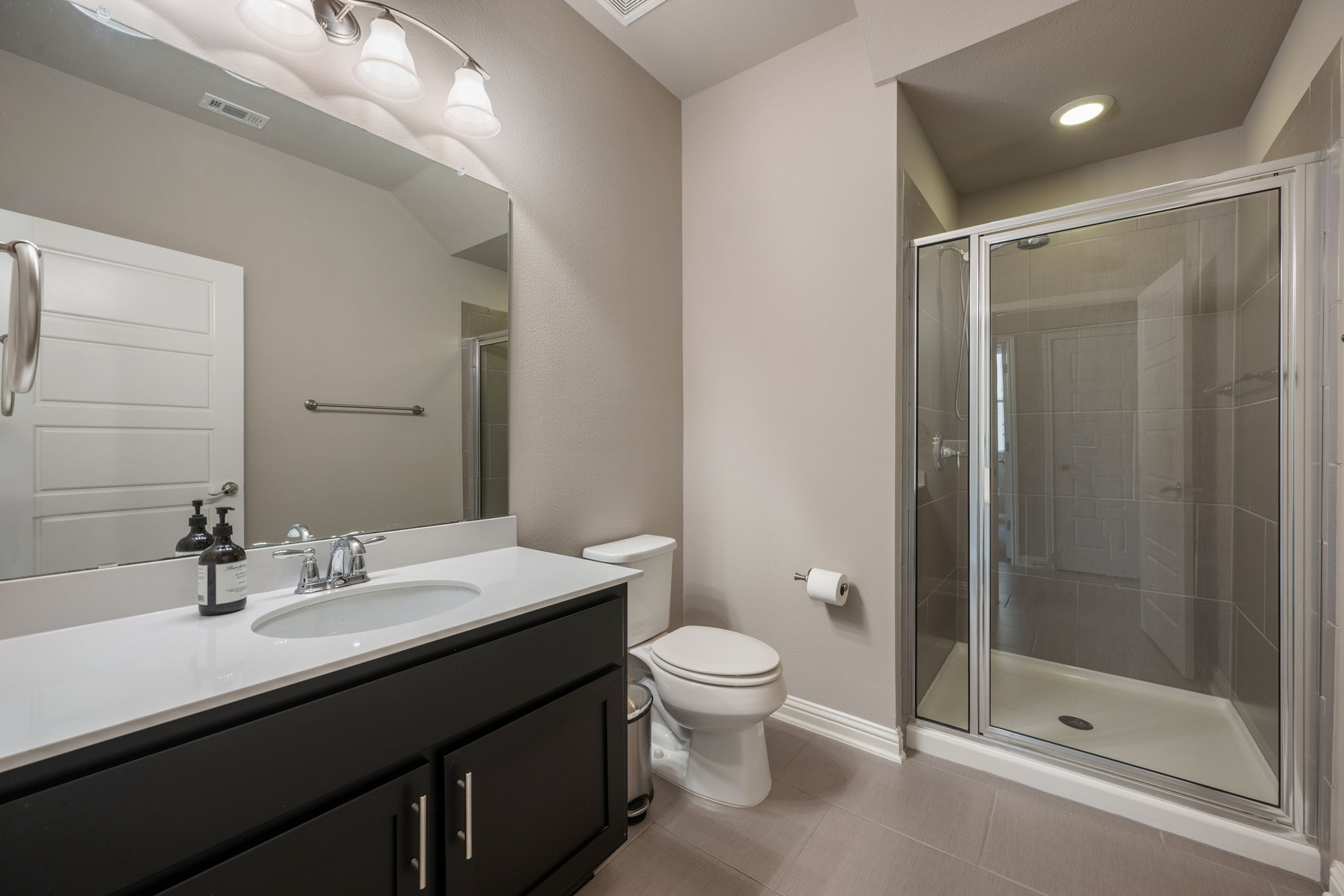 6814 East Riverside Drive, Unit 55 Austin, TX 78741 - Photo 15 of 31 Bathroom featuring vanity, a stall shower, and light tile patterned flooring
