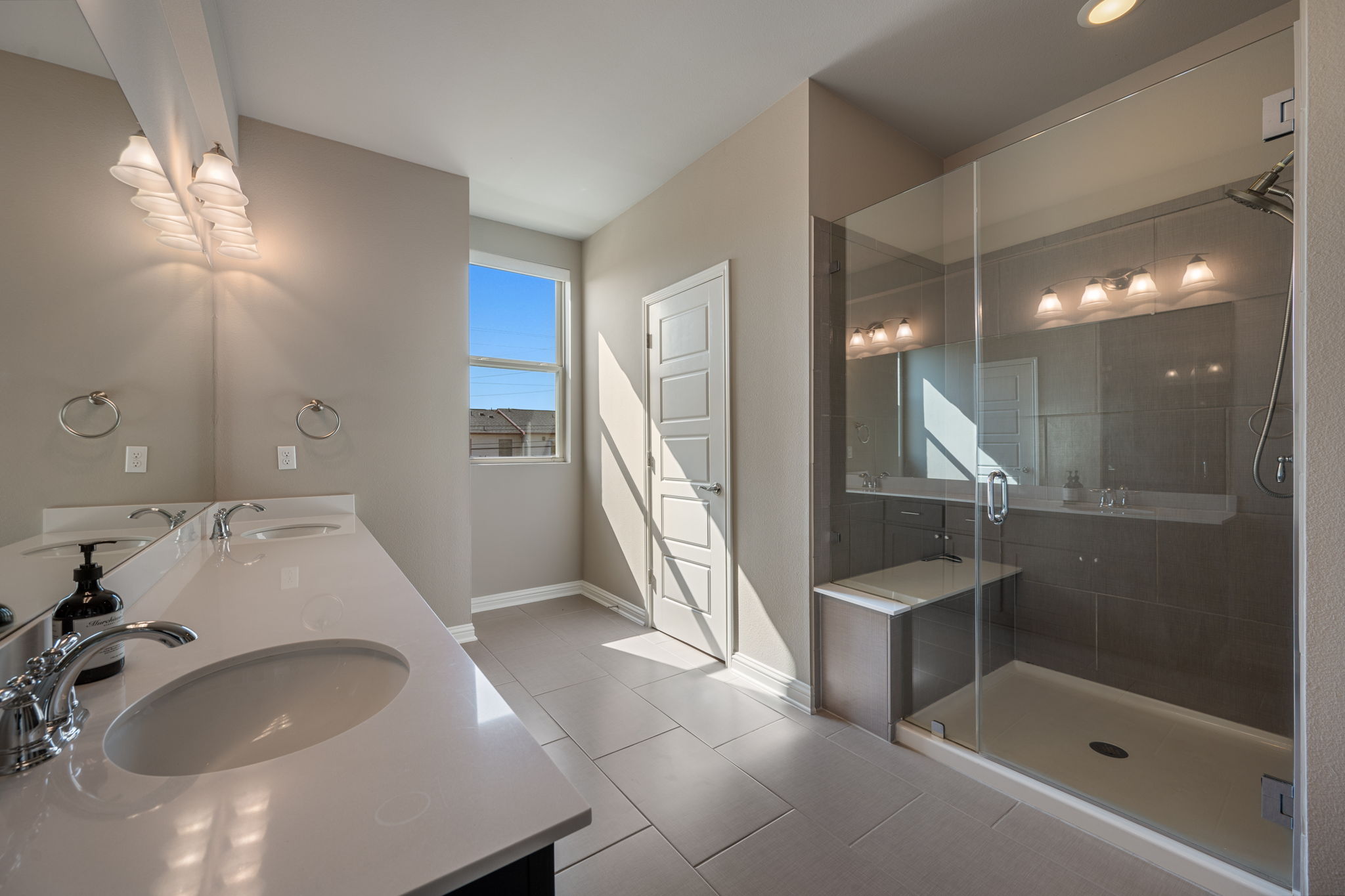 6814 East Riverside Drive, Unit 55 Austin, TX 78741 - Photo 19 of 31 Bathroom featuring a shower stall, double vanity, and light tile patterned flooring