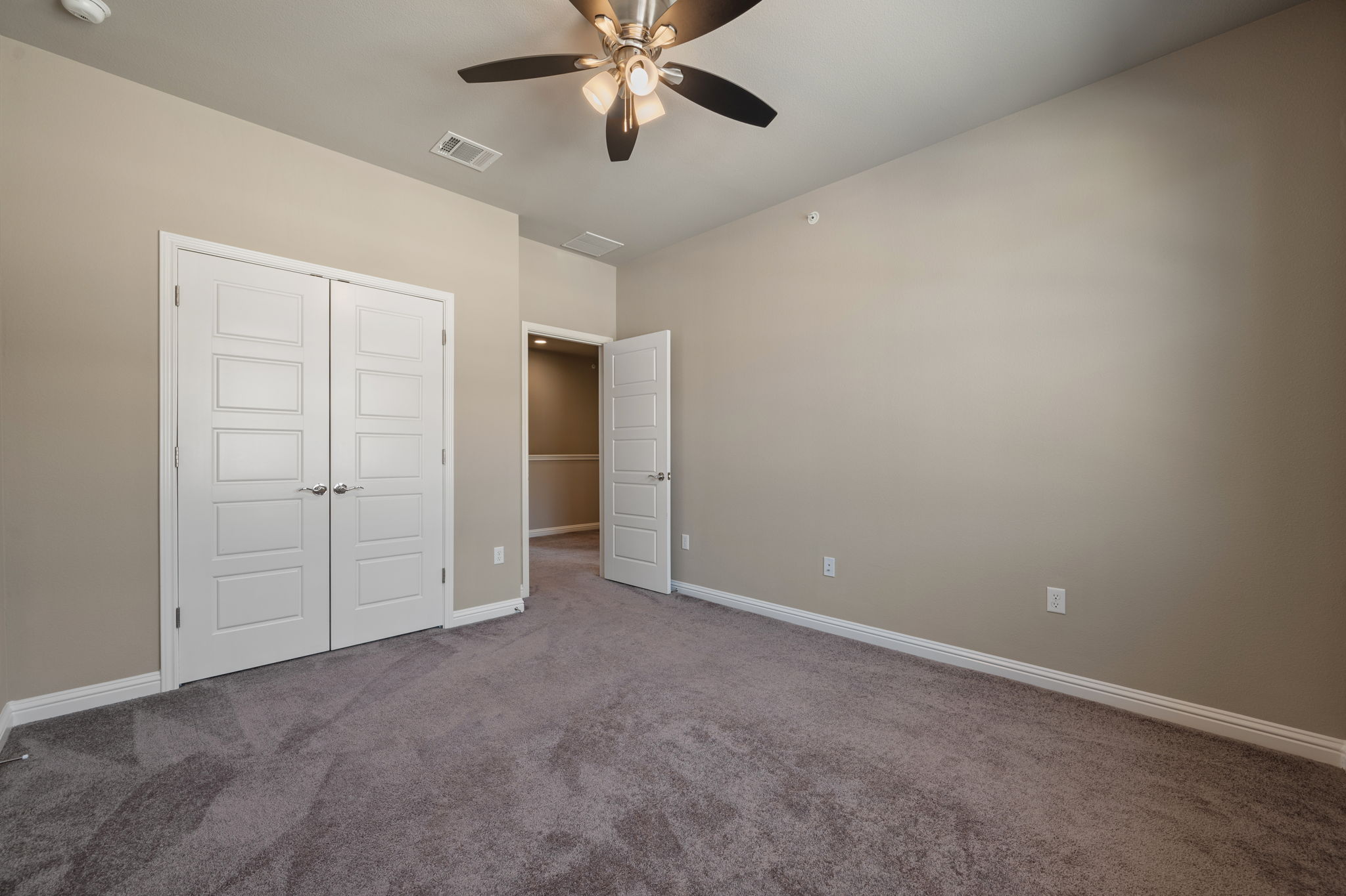 6814 East Riverside Drive, Unit 55 Austin, TX 78741 - Photo 27 of 31 Unfurnished bedroom with carpet flooring, a ceiling fan, and a closet