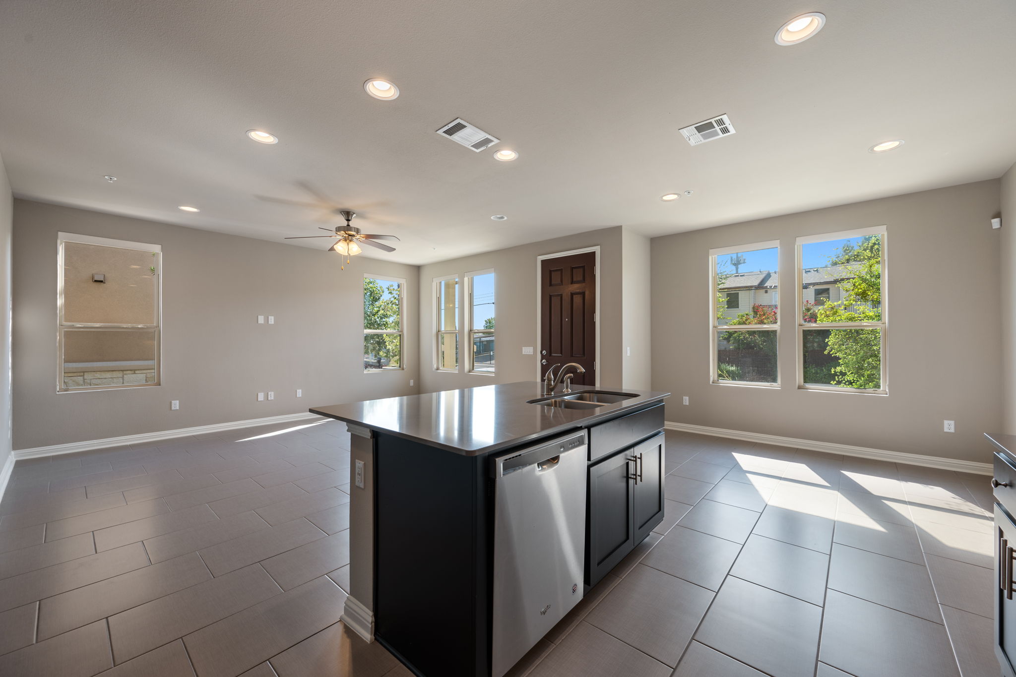 6814 East Riverside Drive, Unit 55 Austin, TX 78741 - Photo 31 of 31 Kitchen with open floor plan, an island with sink, dishwasher, recessed lighting, and dark cabinets