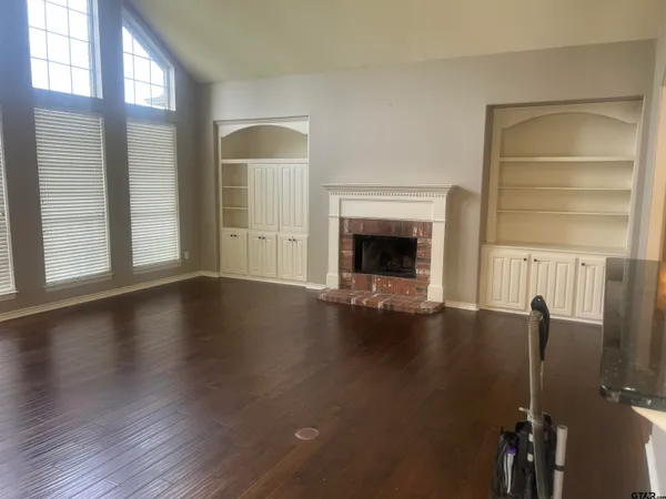 a view of an empty room with a fireplace and a window