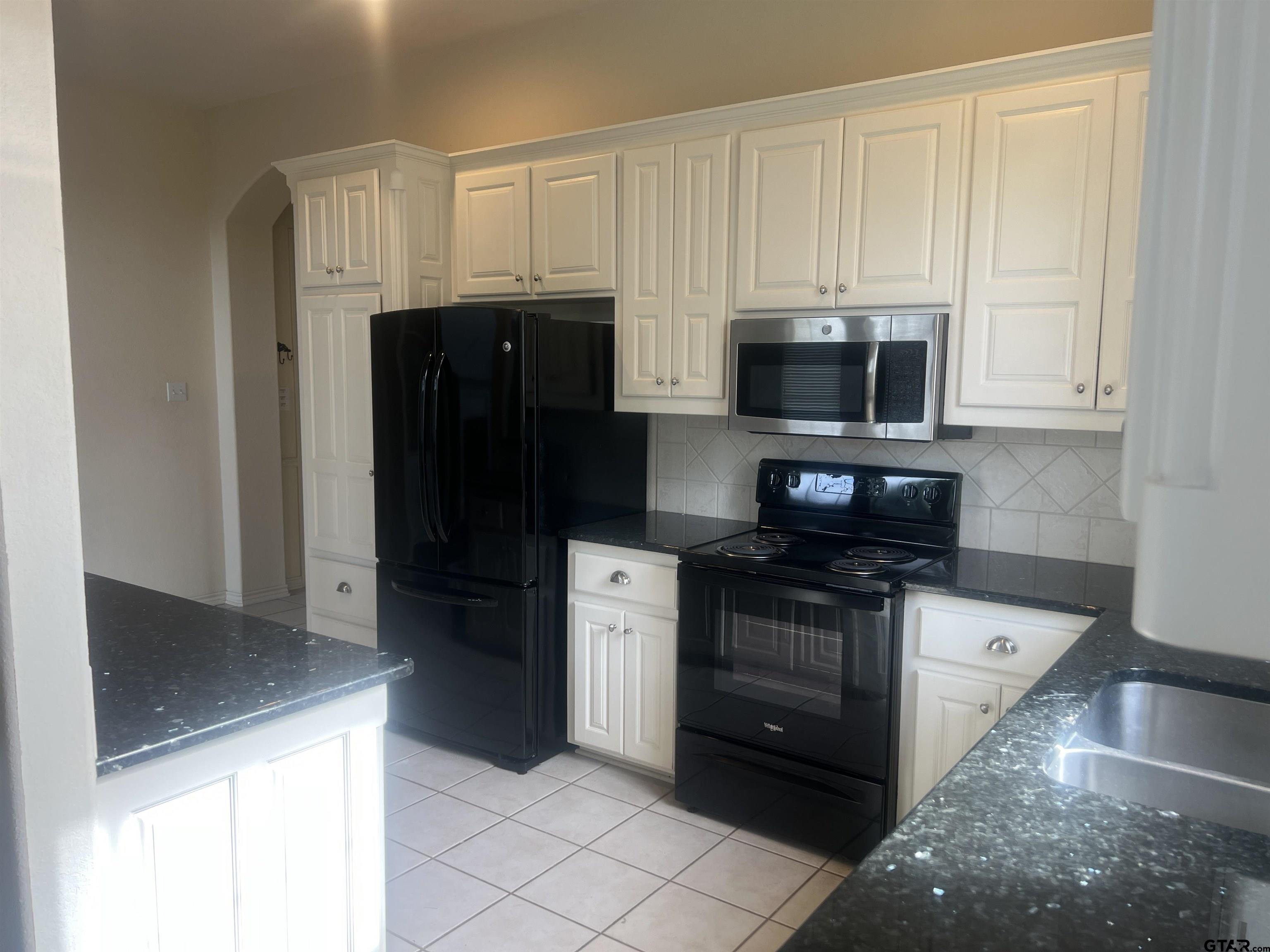 1805 Oak Ridge Street Hideaway, TX 75771 - Photo 4 of 15 a kitchen with stainless steel appliances granite countertop a refrigerator and a stove