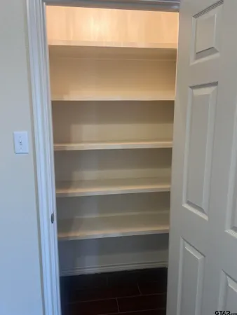 a view of walk in closet with empty racks