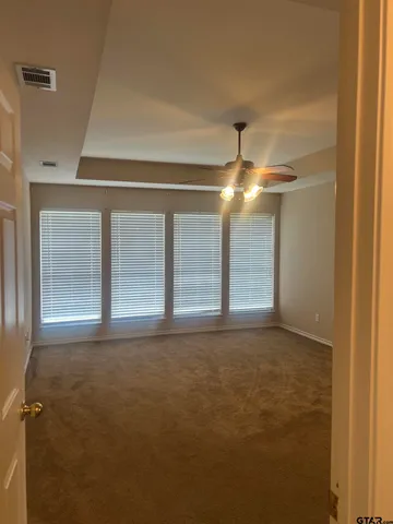 a view of empty room with window and chandelier fan