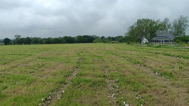 a view of a green field with wooden fence