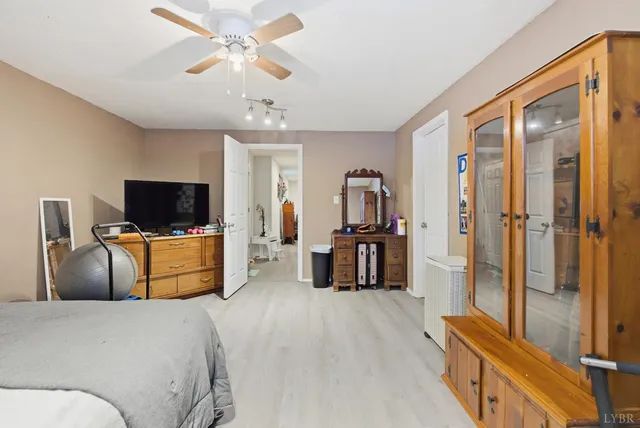 a bedroom with a bed and a flat tv screen on the dresser