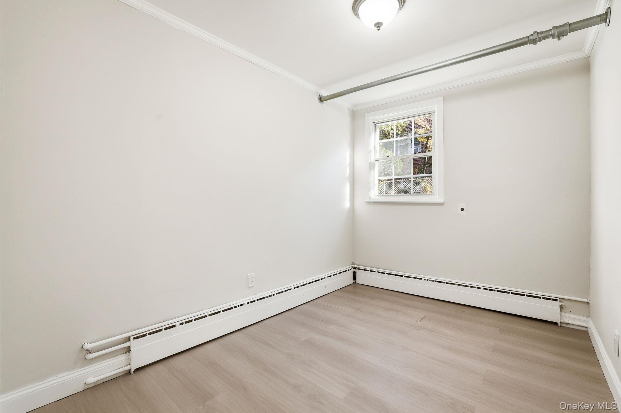 2015 Tenbroeck Avenue Bronx, NY 10461 - Photo 36 of 50 an empty room with a window and wooden floor