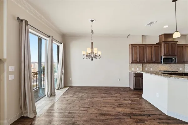 a view of a kitchen with a sink and dishwasher with wooden floor