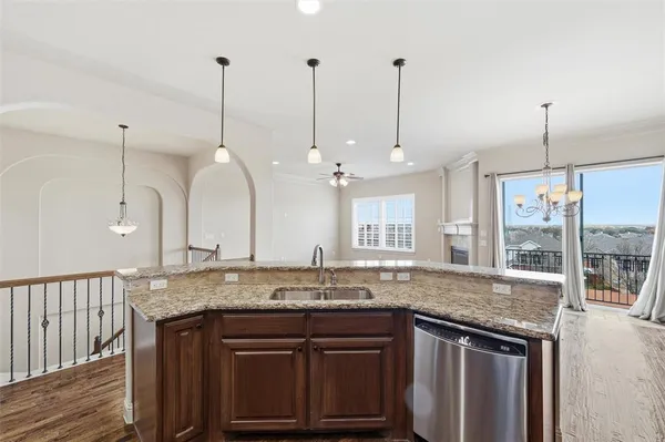 a kitchen with granite countertop a sink a counter space and stainless steel appliances