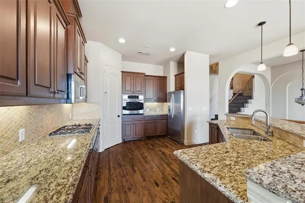 a kitchen with granite countertop stainless steel appliances and wooden cabinets