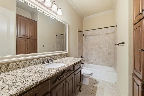 a bathroom with a granite countertop sink a toilet a mirror and shower