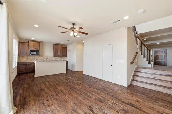 a view of a kitchen with a sink a ceiling fan and wooden floor