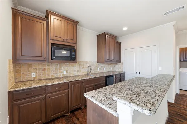 a kitchen with stainless steel appliances granite countertop a sink stove and microwave