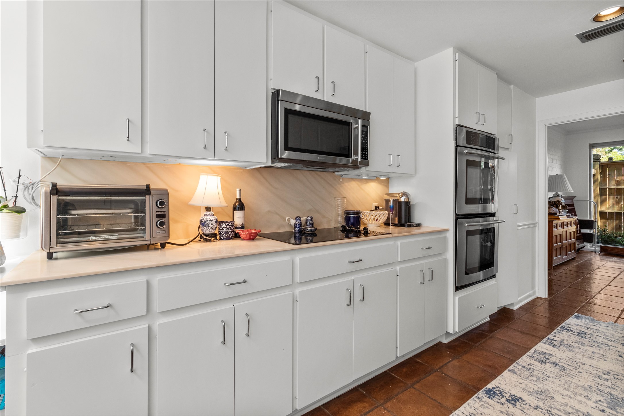 201 Vanderpool Lane, Unit 103 Houston, TX 77024 - Photo 15 of 28 a kitchen with stainless steel appliances granite countertop white cabinets and a stove top oven