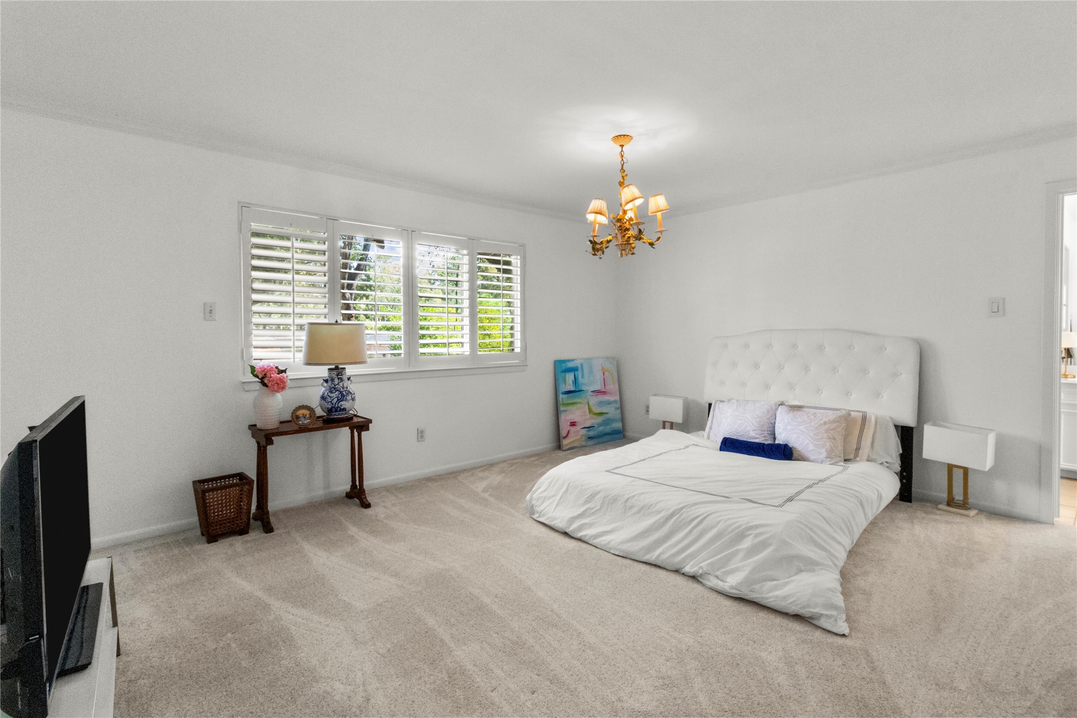 201 Vanderpool Lane, Unit 103 Houston, TX 77024 - Photo 24 of 28 a bedroom with a bed and a chandelier