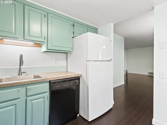 a kitchen with a sink a refrigerator and cabinets