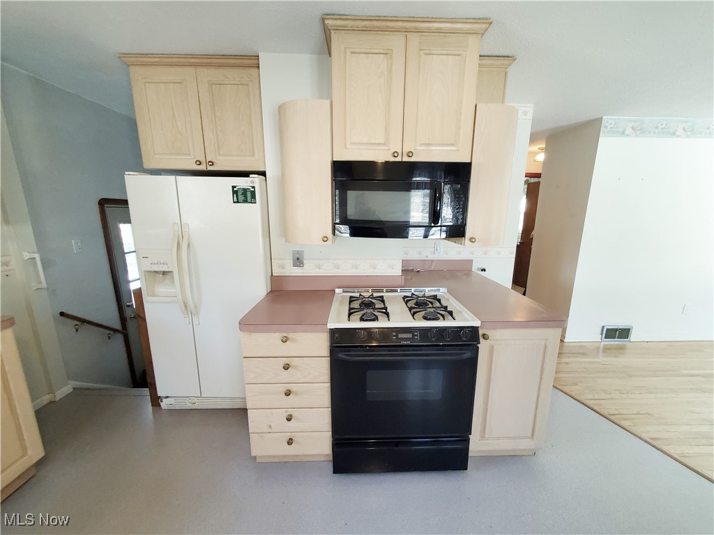 Oak cabinets with refrigerator, gas range and microwave