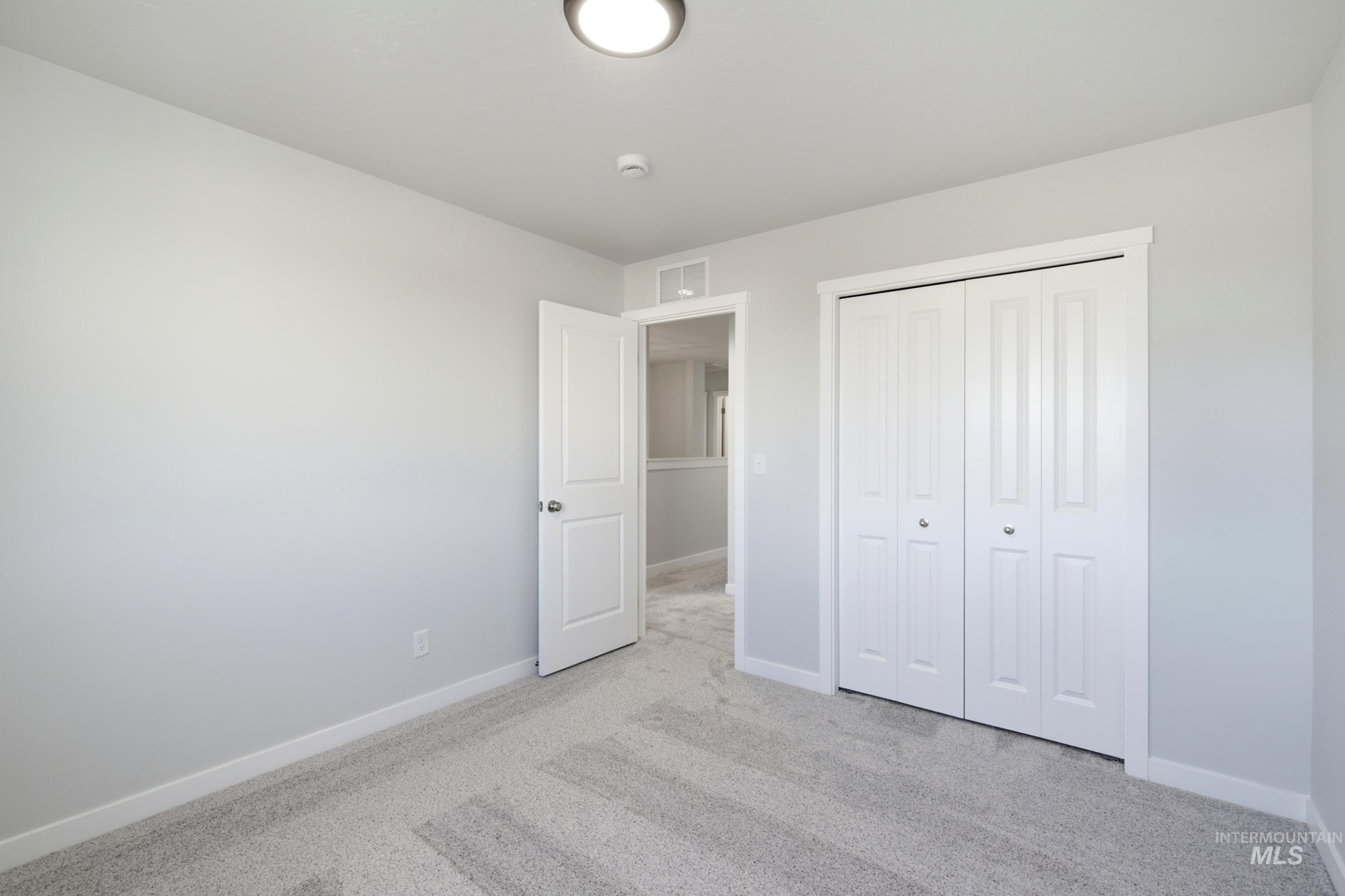 13324 Bank Street Caldwell, ID 83607 - Photo 20 of 29 Carpeted flooring, white trim, bi-fold closet doors, flush-mount ceiling light