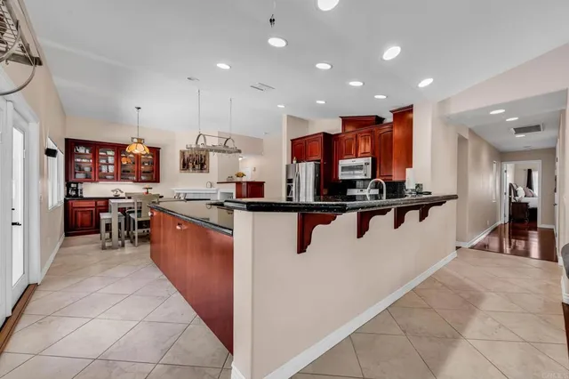 a living room with furniture a piano and a potted plant