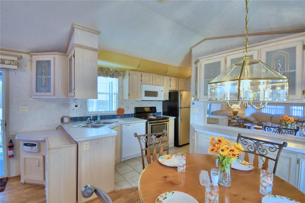 251 Patterson Road, Unit H17 Haines City, FL 33844 - Photo 14 of 47 a kitchen with stainless steel appliances granite countertop a stove a sink a dining table and chairs