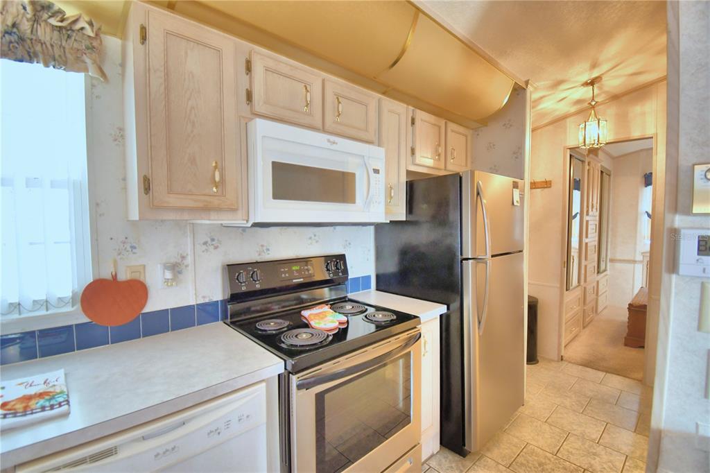 251 Patterson Road, Unit H17 Haines City, FL 33844 - Photo 18 of 47 a kitchen with stainless steel appliances a refrigerator stove and cabinets