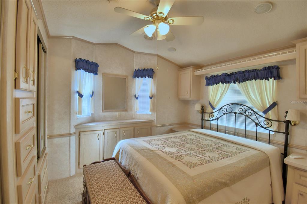 251 Patterson Road, Unit H17 Haines City, FL 33844 - Photo 23 of 47 a bedroom with a bed and a chandelier