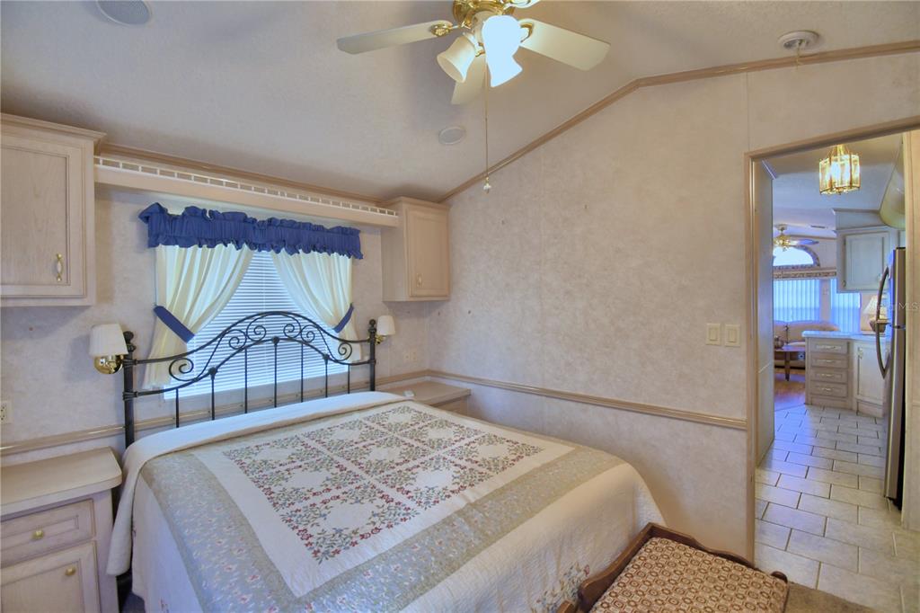 251 Patterson Road, Unit H17 Haines City, FL 33844 - Photo 24 of 47 a bedroom with a large bed and a chandelier
