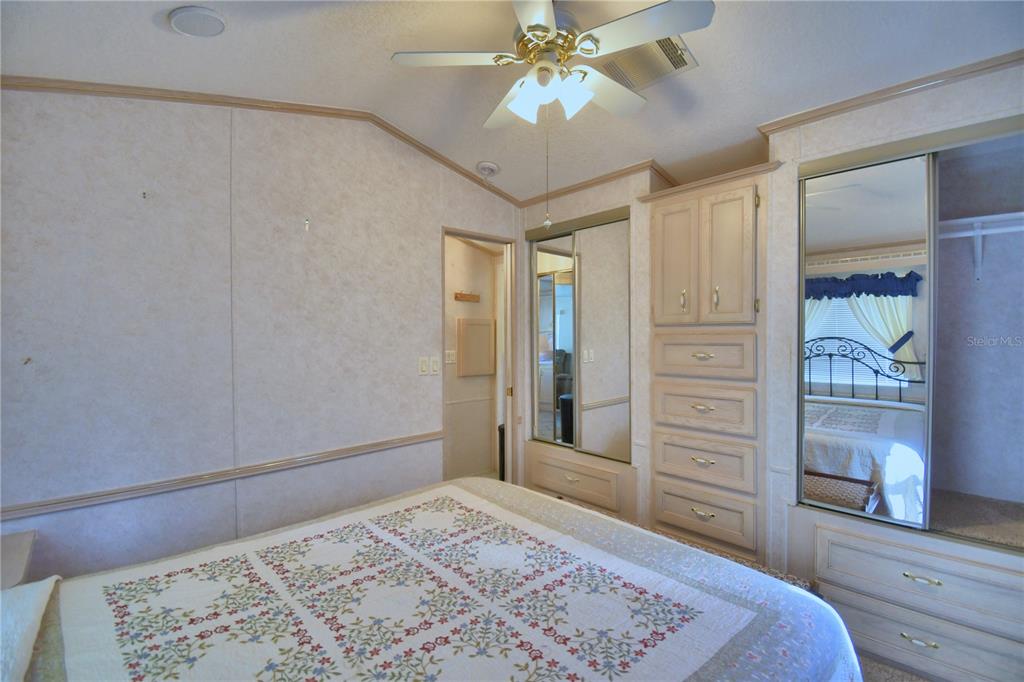 251 Patterson Road, Unit H17 Haines City, FL 33844 - Photo 25 of 47 a bedroom with a bed and a chandelier