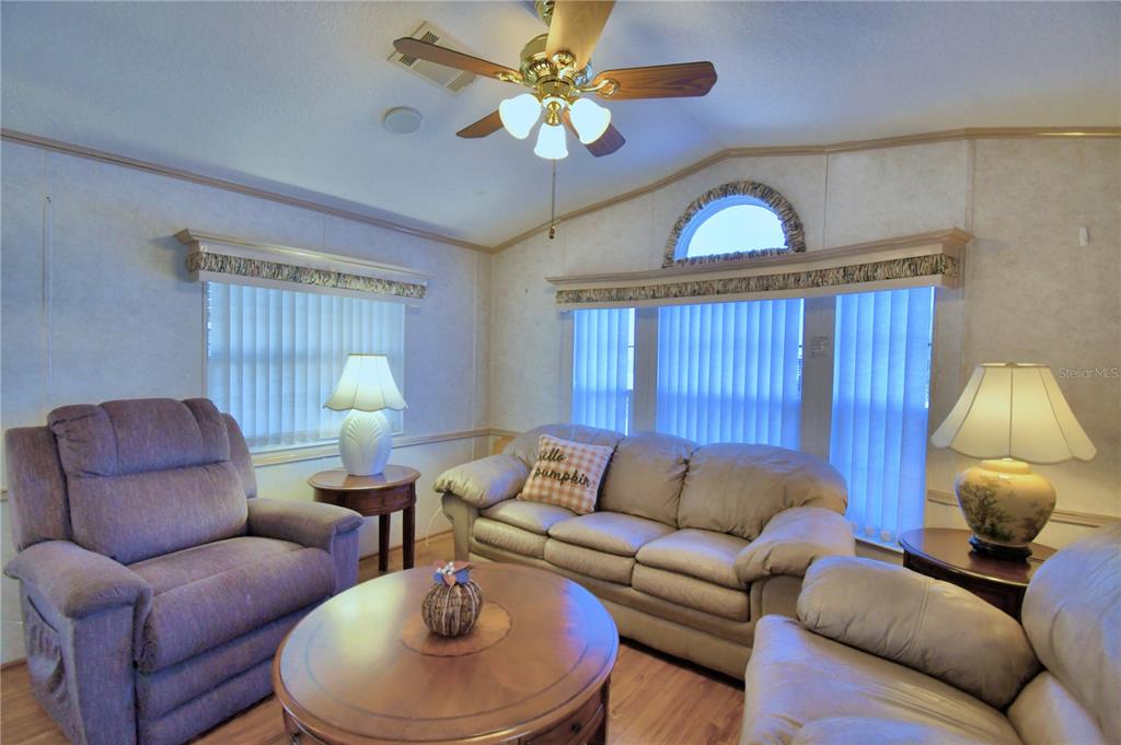 251 Patterson Road, Unit H17 Haines City, FL 33844 - Photo 9 of 47 a living room with furniture a chandelier and a window