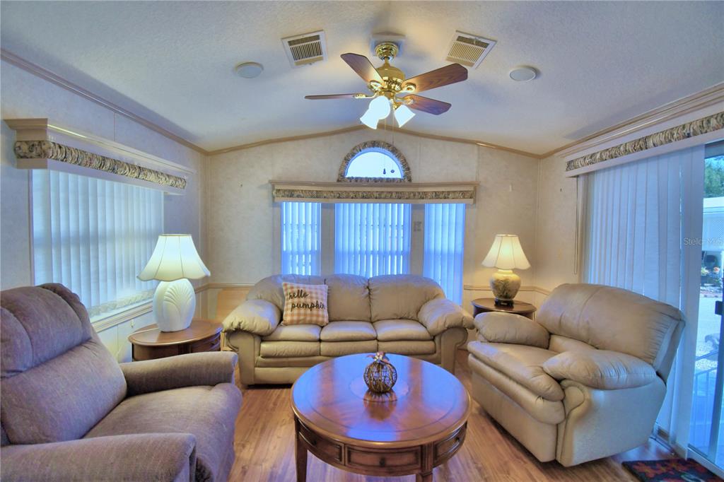 251 Patterson Road, Unit H17 Haines City, FL 33844 - Photo 10 of 47 a living room with furniture a chandelier and a fireplace