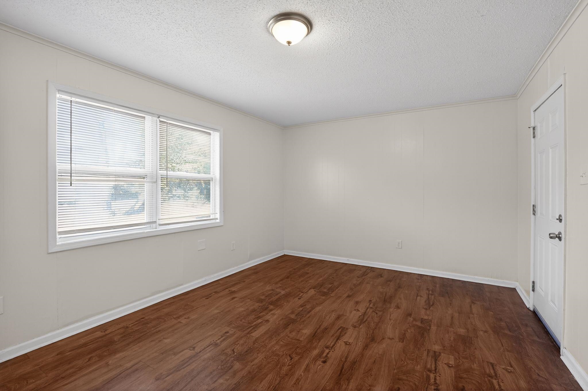 3637 Neely Road Memphis, TN 38109 - Photo 15 of 30 an empty room with wooden floor and windows