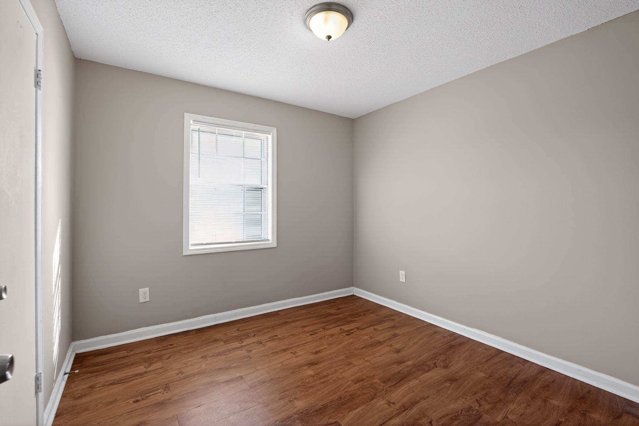 3637 Neely Road Memphis, TN 38109 - Photo 16 of 30 an empty room with wooden floor and windows